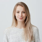 pretty smiling joyfully female with fair hair dressed casually looking with satisfaction