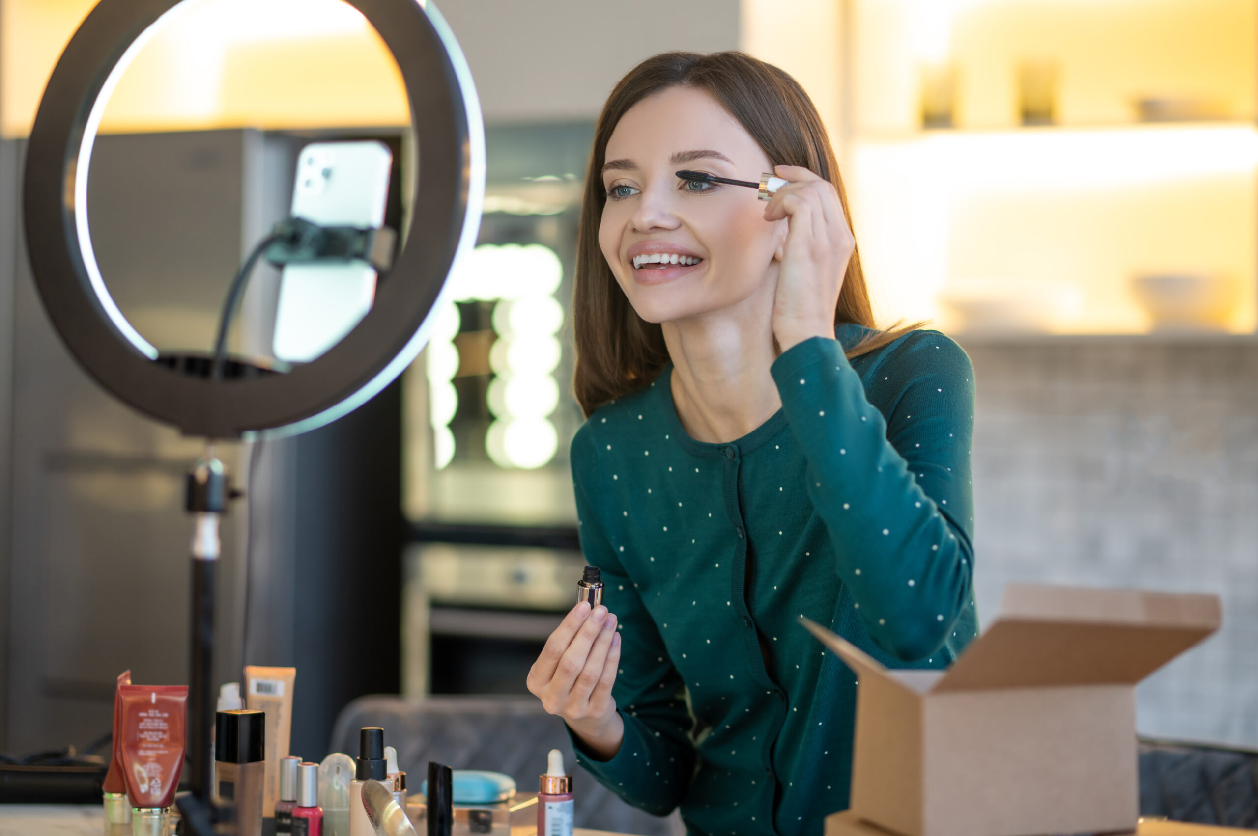 Young beautiful woman demonstrating new mascara and looking amused New mascara presentation. Young beautiful woman demonstrating new mascara and looking amused